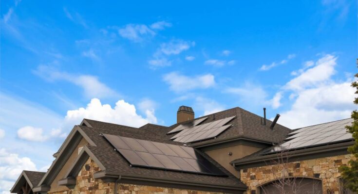 Many solar panels are installed to the roof of a modern residential home to provide sustainable energy for its residents.