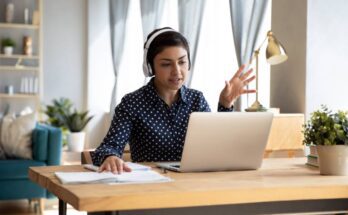 A remote worker sits at their desk in a beautifully decorated home office while hosting a virtual meeting.
