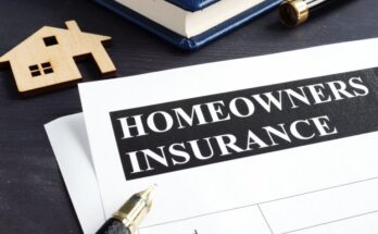 A paper document with a header reading “HOMEOWNERS INSURANCE” on a desk near an uncapped pen.