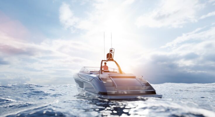 A man is driving a boat on an open body of water towards the sunset. The water has waves, and the sky has clouds.