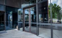 A commercial business with double-glass doors and vertical stainless steel handles for ADA-compliance.