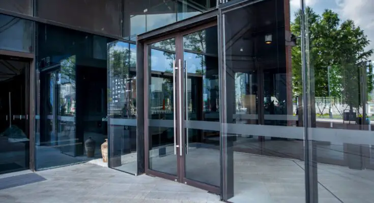 A commercial business with double-glass doors and vertical stainless steel handles for ADA-compliance.