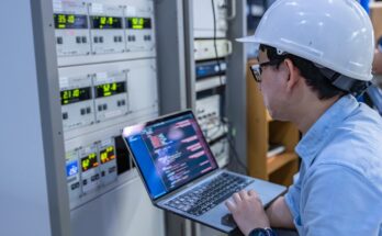 An electrical engineer is checking the voltage at the Power Distribution Cabinet in the control room.