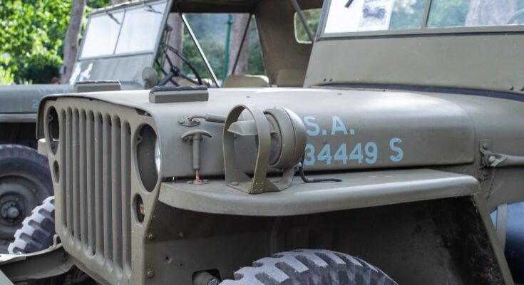 A close-up view of the front end of a restored 1941 Willys MB military Jeep. The Jeep is painted its authentic color.
