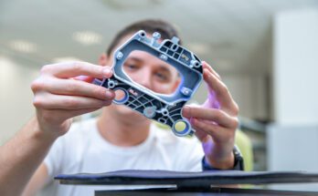 A close-up of a quality engineer examines a laser-scanned sample during a 3D scan in a research laboratory.