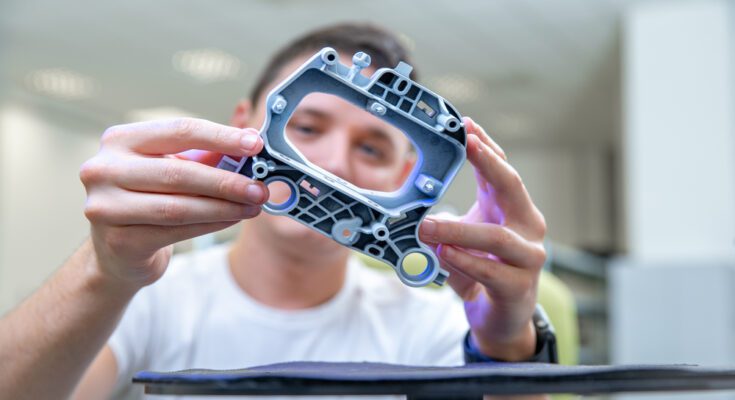 A close-up of a quality engineer examines a laser-scanned sample during a 3D scan in a research laboratory.