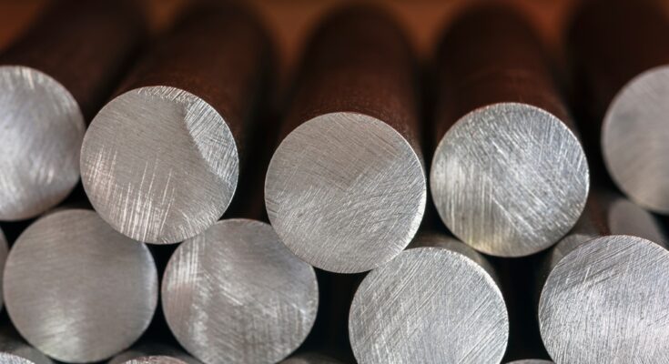 A close-up of cylindrical steel components from a heavy industry plant stacked on top of one another.
