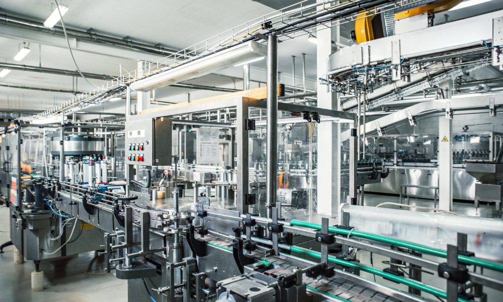 Industrial beverage production line featuring automated conveyors, bottling machinery, and stainless steel equipment.